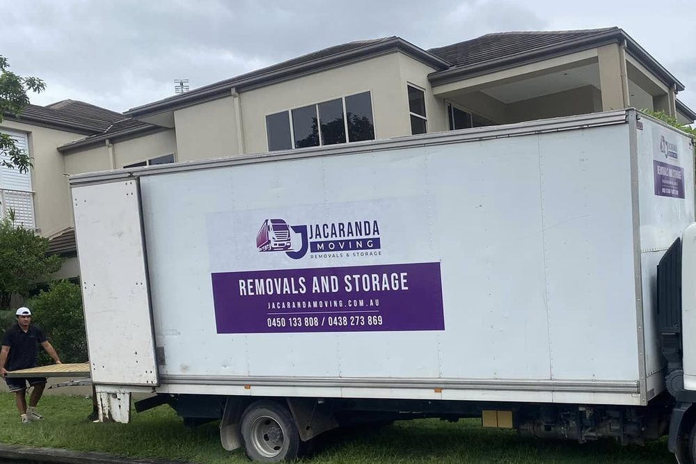 Two branded Jacaranda trucks on a residential removal